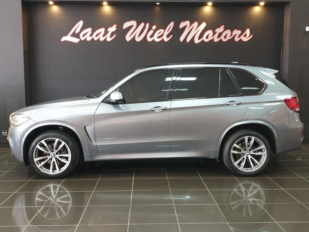Silver BMW X5 SUV displayed in showroom