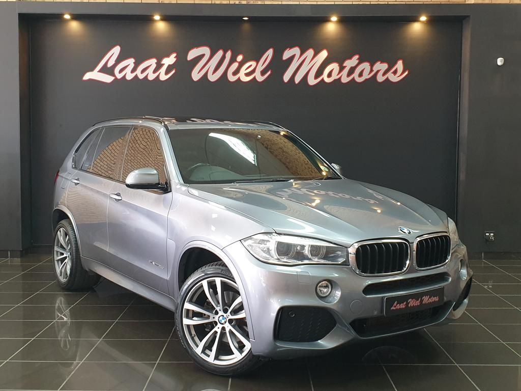 Silver BMW SUV displayed inside Laat Wiel Motors showroom