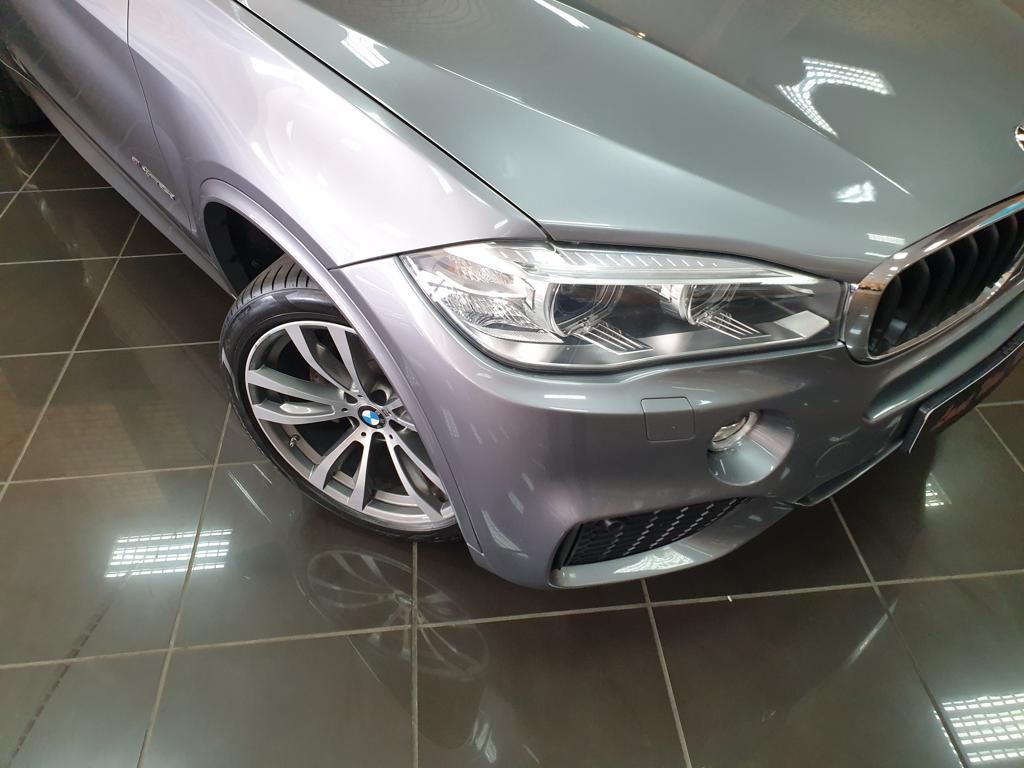 Gray BMW front corner with alloy wheel in showroom