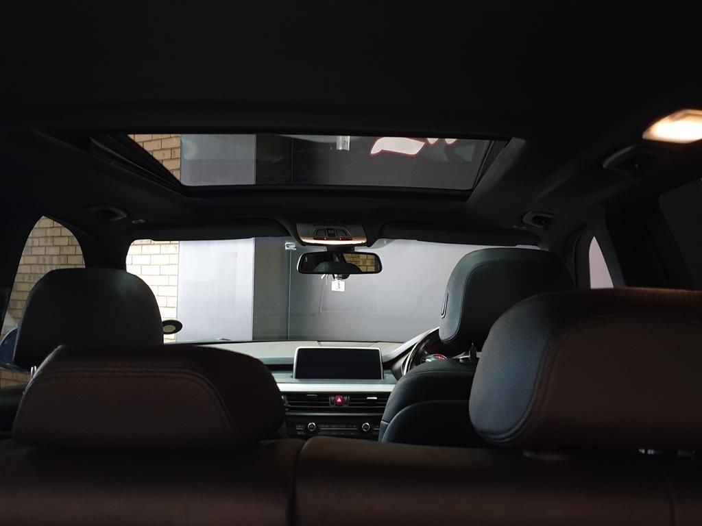 Car interior with black seats, dashboard, and panoramic sunroof