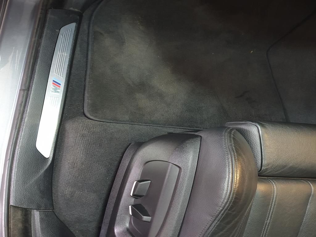 BMW M door sill beside leather seat and floor mat