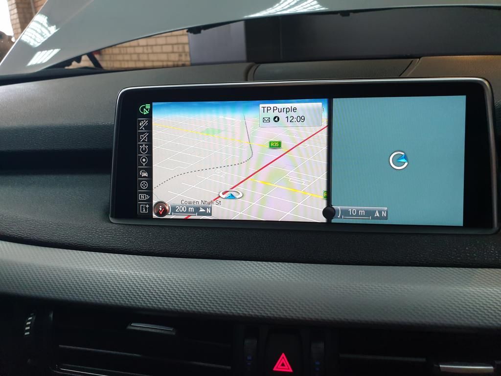 Car dashboard navigation screen displaying split map view