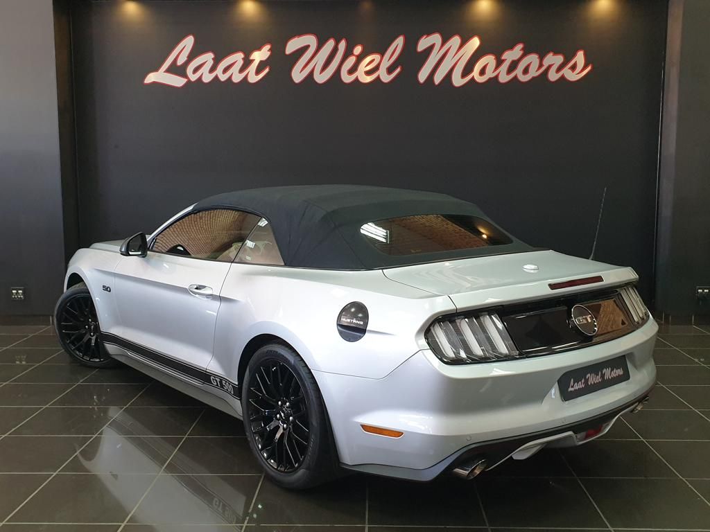 White Ford Mustang GT convertible displayed in a showroom