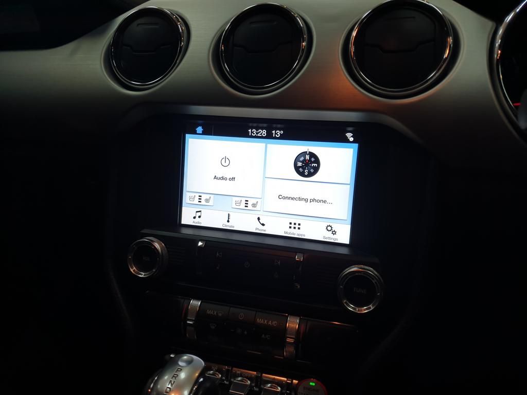 Car dashboard touchscreen displaying audio and phone connection settings