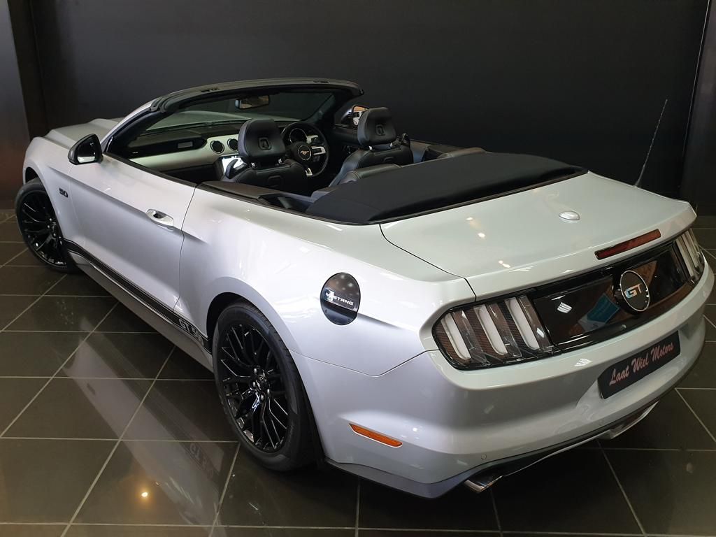 White Ford Mustang convertible displayed in a showroom