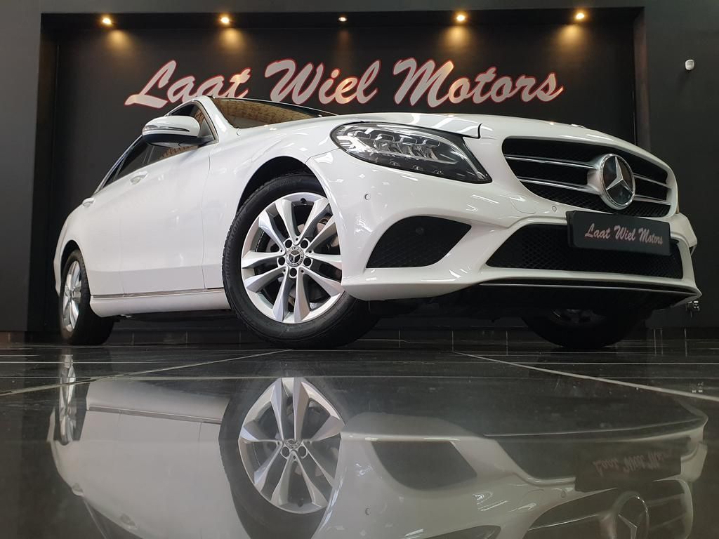 White Mercedes-Benz coupe displayed in a luxury showroom
