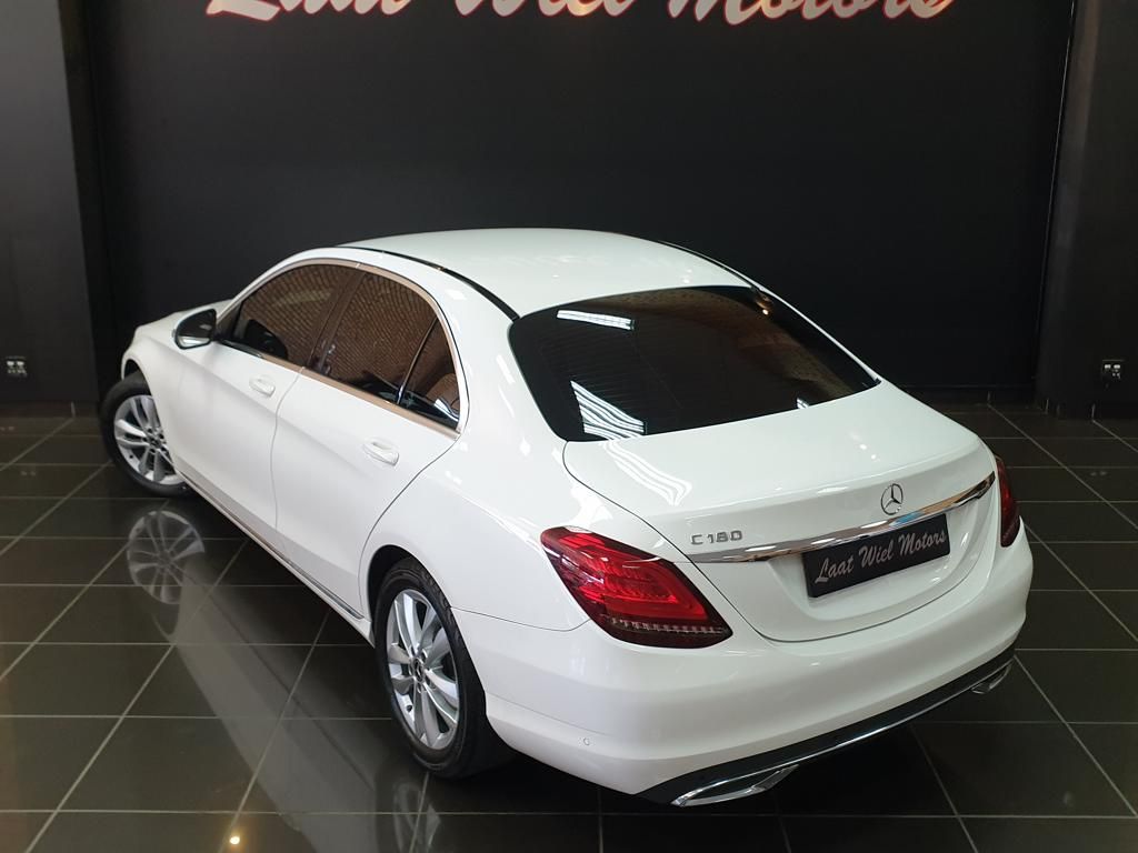 White Mercedes-Benz C180 sedan displayed in showroom