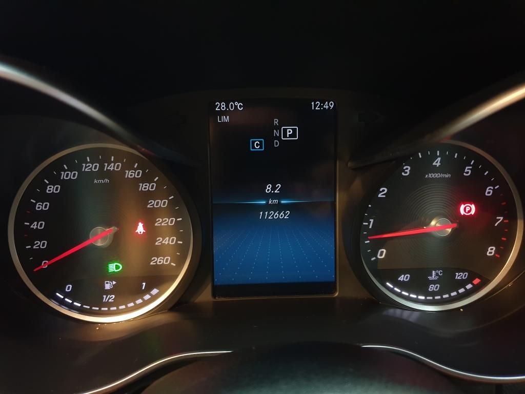 Car dashboard displaying speedometer, tachometer, and warning lights