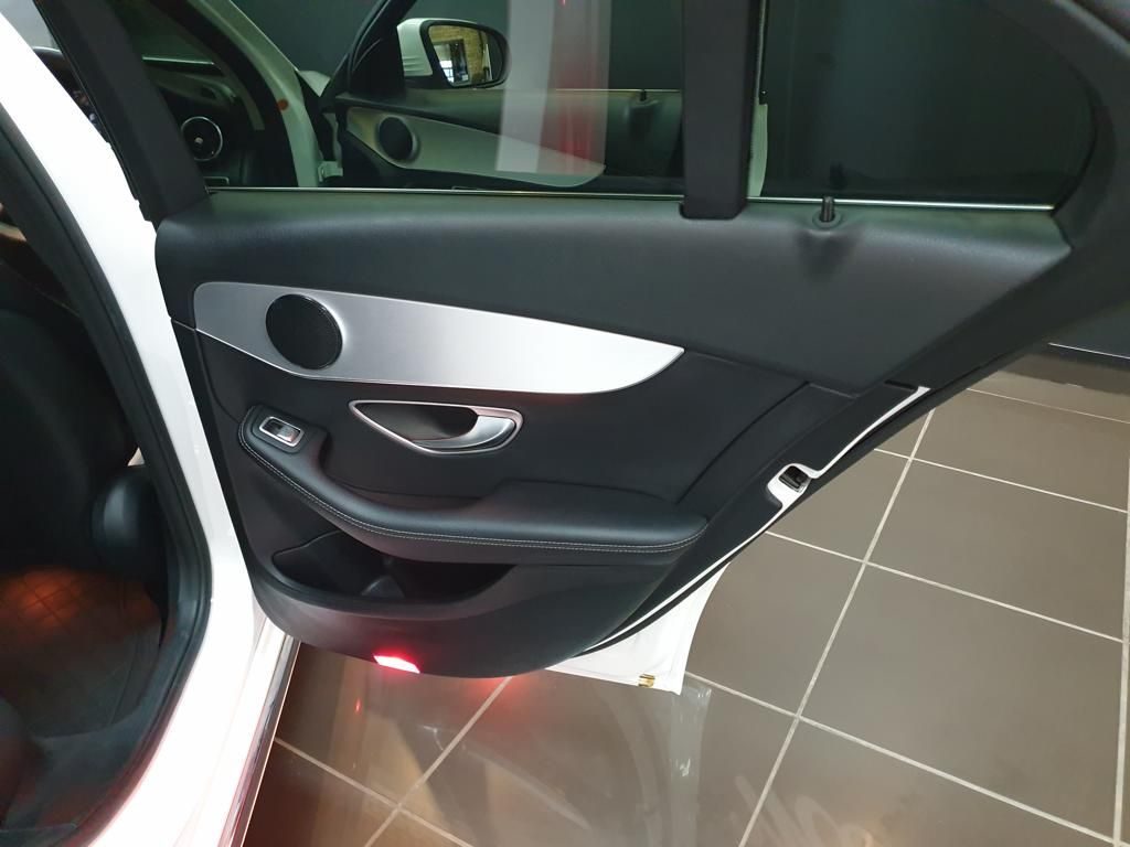 Black leather car door panel with silver trim and speaker