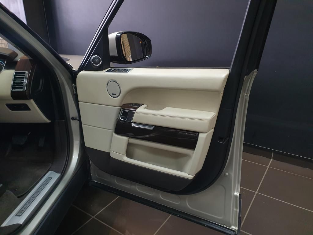 Luxury vehicle interior door with cream leather and wood trim