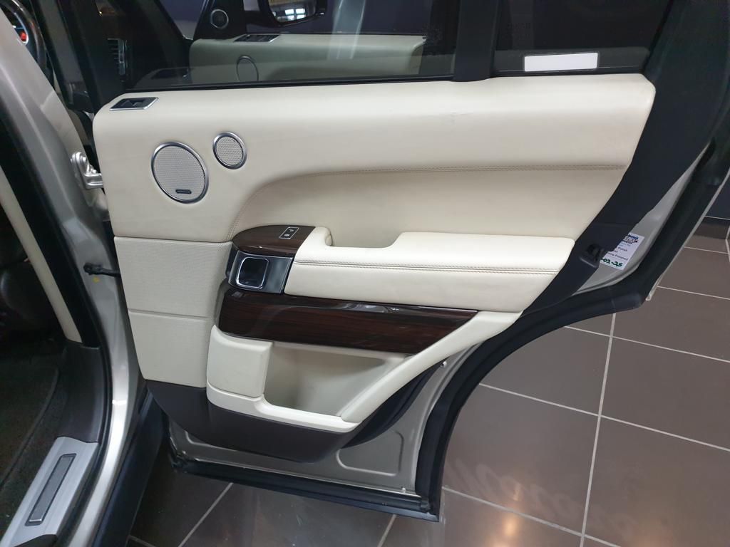 Luxury beige car door panel with wood trim and speakers