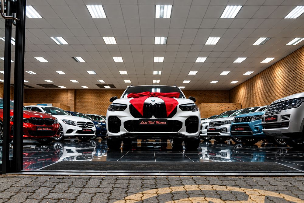 White BMW with red bow in luxury car showroom